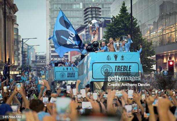 Manchester City's Rúben Dias lifts the Champions League trophy during the Manchester City trophy parade on June 12, 2023 in Manchester, England.