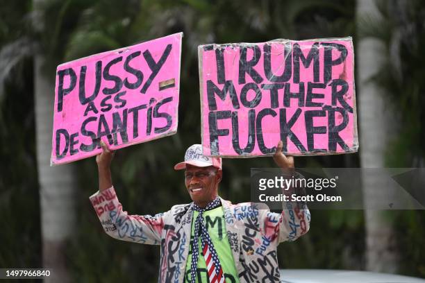 An anti-Trump demonstrator confronts supporters of former President Donald Trump as they wait for him to arrive at the Trump National Doral Miami...