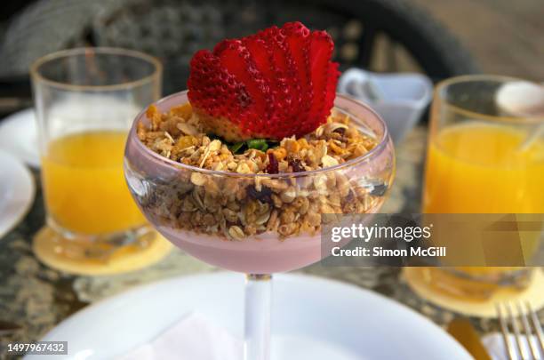 parfait of strawberry yogurt, muesli and a fresh strawberry served in a champagne coupe glass - coupe dessert stock pictures, royalty-free photos & images