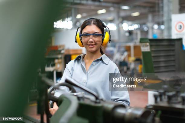 female apprentice engineer working with cnc machine in factory - engine room stock pictures, royalty-free photos & images