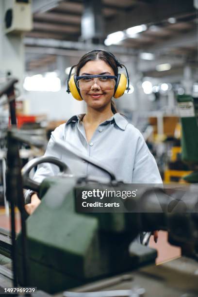 female apprentice engineer working with cnc machine in factory - industrial labourer stock pictures, royalty-free photos & images