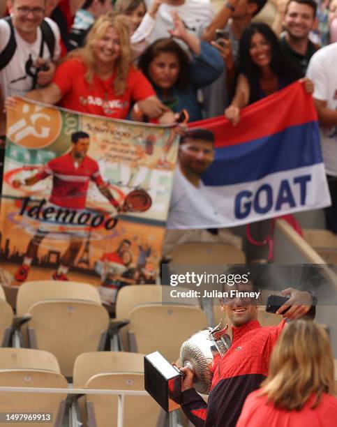 Novak Djokovic of Serbia has a selfie taken after defeating Casper Ruud of Norway in the Men's Singles Final match on Day Fifteen of the 2023 French...