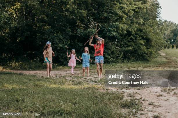 group of little girls play in the mud while enjoying nature during summer camp - cousin stock pictures, royalty-free photos & images