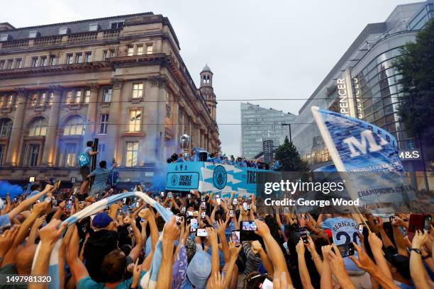 Manchester City players celebrate on the open top bus during the Manchester City trophy parade on June 12, 2023 in Manchester, England.