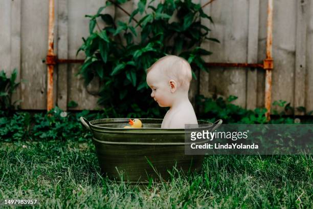 アンティークの浴槽の男の子 - おもちゃのアヒル ストックフォトと画像