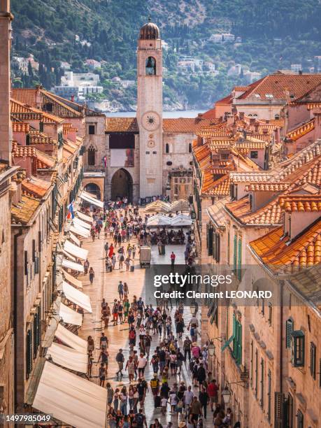 tourists walking in dubrovnik main street, the stradun (placa), as seen from above from the fortified walls in the old town, dalmatia, croatia. - town orange stock-fotos und bilder