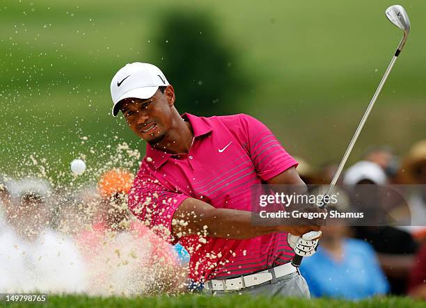 Tiger Woods plays a shot from a sand trap on the ninth hole during the third round of the World Golf Championships-Bridgestone Invitational at...