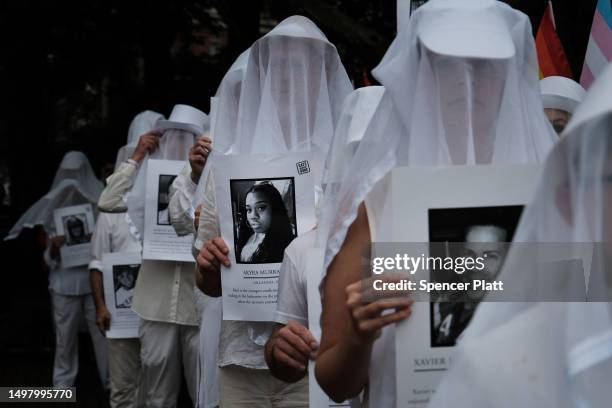 Members of the activist group Gays Against Guns hold pictures of the deceased during a silent vigil to mark seven years since the Pulse Nightclub...