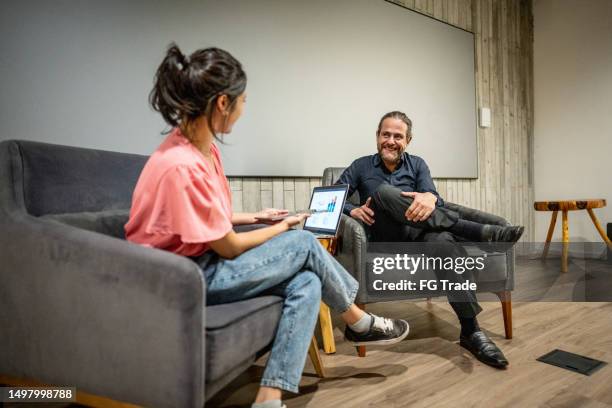 young woman interviewing a man at studio - media interview stock pictures, royalty-free photos & images