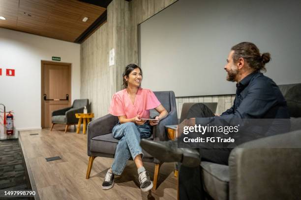 young woman interviewing a man at studio - media interview stockfoto's en -beelden