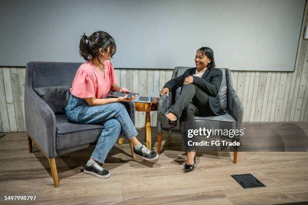 giovane donna che intervista una donna in studio - intervista-giornalistica foto e immagini stock