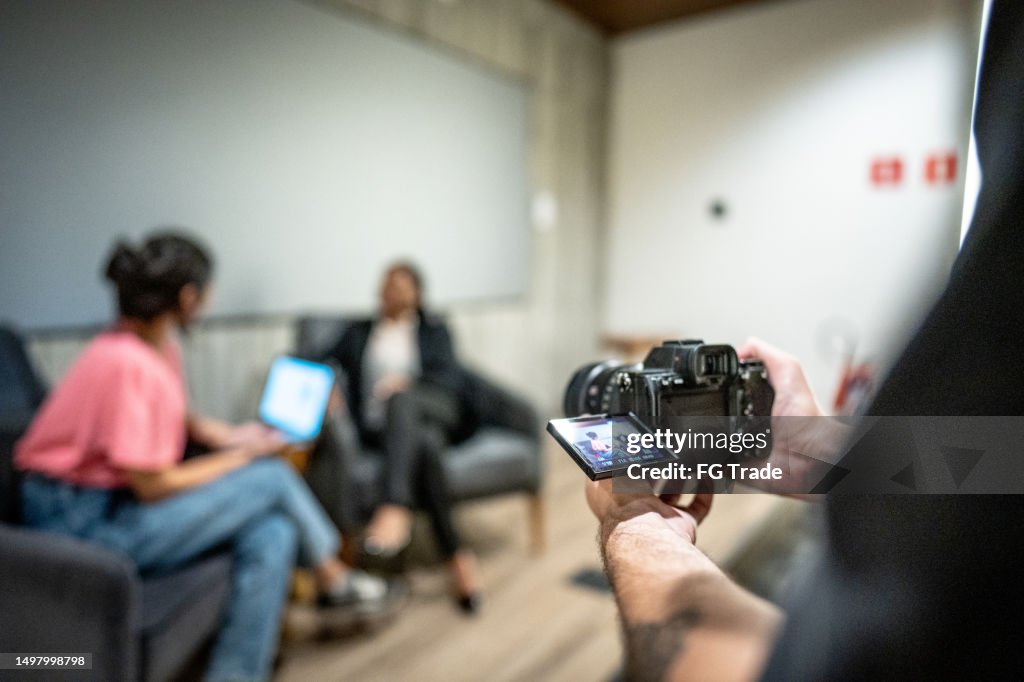 Cameraman che registra video con la telecamera in un seminario