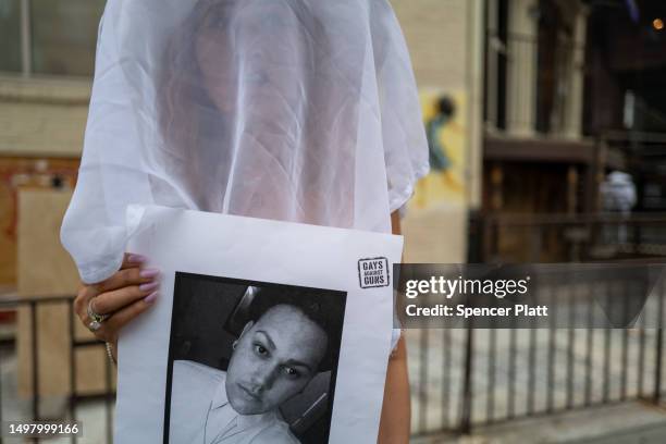 Members of the activist group Gays Against Guns hold pictures of the deceased during a silent vigil to mark seven years since the Pulse Nightclub...