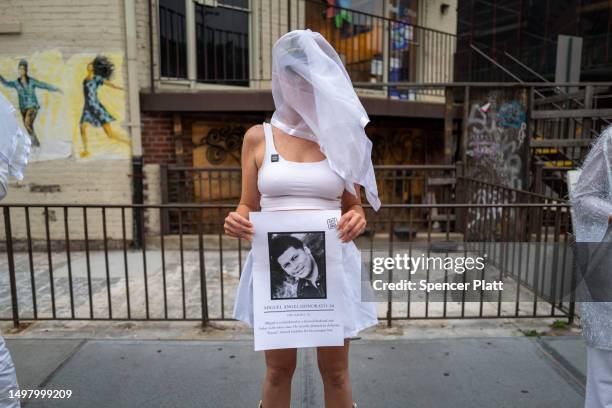 Members of the activist group Gays Against Guns hold pictures of the deceased during a silent vigil to mark seven years since the Pulse Nightclub...