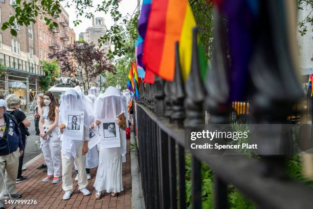 Members of the activist group Gays Against Guns hold pictures of the deceased during a silent vigil to mark seven years since the Pulse Nightclub...