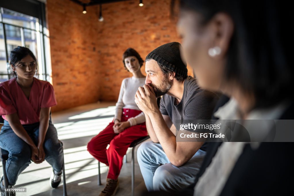 Mid adult man talking during a therapy group