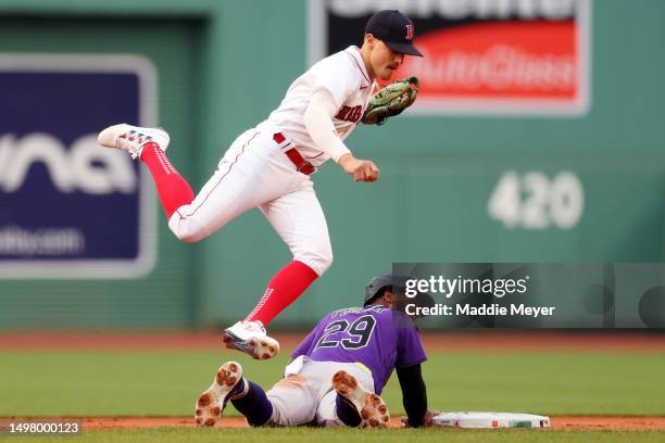 Enrique Hernandez of the Boston Red Sox jumps over Jurickson Profar of the Colorado Rockies after Profar slides safe into second during the first...