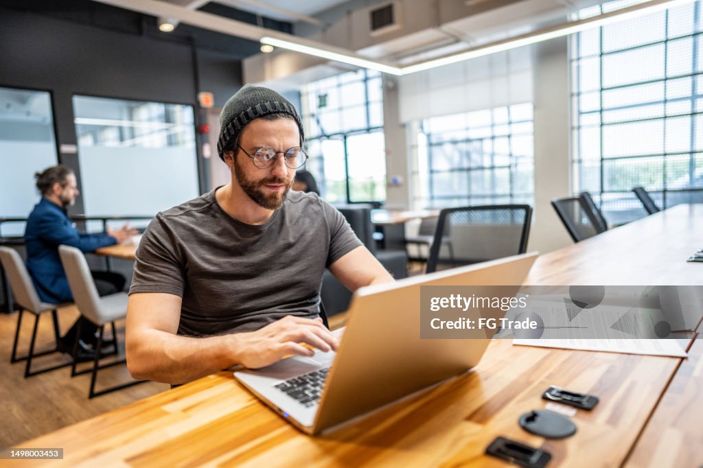 Mid adult businessman working using laptop at office/coworking