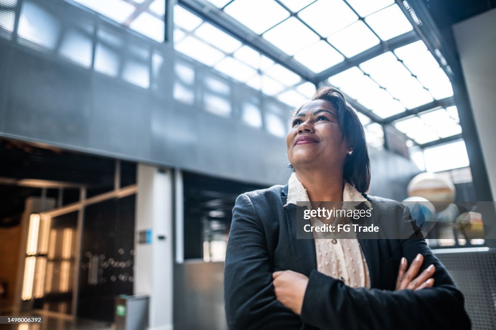 Mature businesswoman contemplating at office lobby