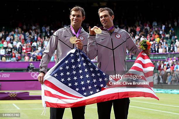 Mike Bryan and Bob Bryan pose with their gold medals and American flag after defeating Jo-Wilfried Tsonga and Michael Llodra of France in their Men's...