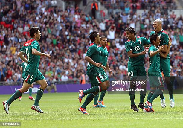 Javier Aquino of Mexico is congratulated by teammates after he scored a goal during the Men's Football Quarter Final match between Mexico and...