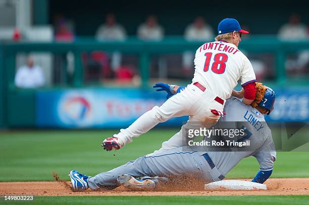 James Loney of the Los Angeles Dodgers slides into second and collides with Mike Fontenot of the Philadelphia Phillies as he defends his position...