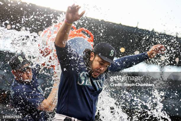 Jarred Kelenic douses Eugenio Suarez of the Seattle Mariners with water after their 8-1 win against the Miami Marlins at T-Mobile Park on June 12,...