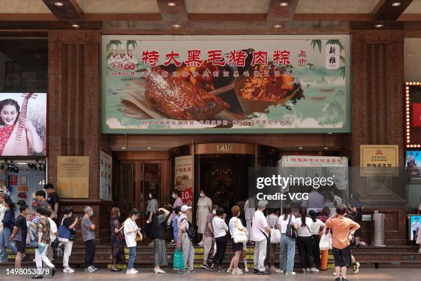 People queue up to purchase Zongzi in front of a store on Nanjing Road pedestrian street ahead of Dragon Boat Festival on June 12, 2023 in Shanghai,...