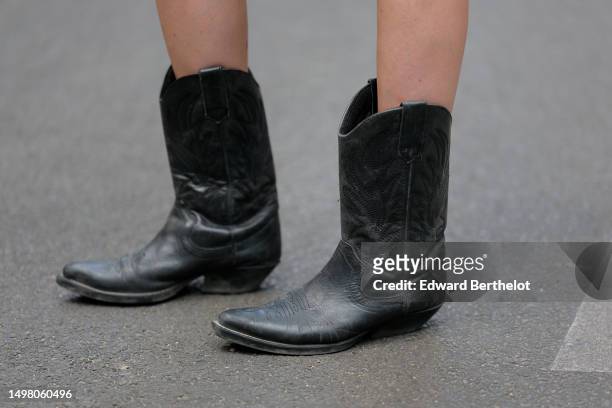 Emy Venturini wears black shiny leather seams pattern ankle boots, during a street style fashion photo session, on June 09, 2023 in Paris, France.