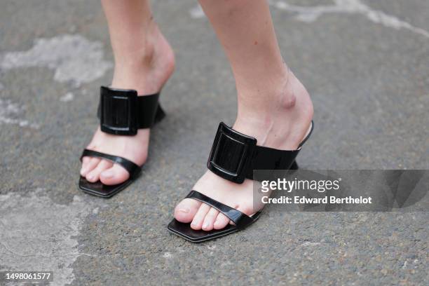 Emy Venturini wears black shiny varnished leather strappy / wedge heels mules from Roger Vivier, during a street style fashion photo session, on June...
