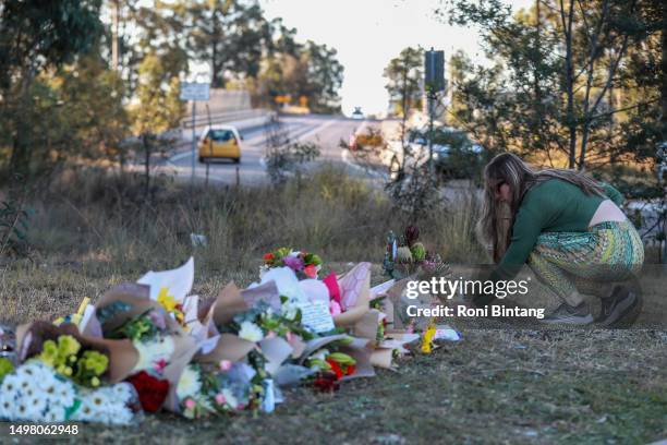 Woman lays flowers near the site of a bus crash on June 13, 2023 in Cessnock, Australia. A horrific bus crash in the Hunter Valley killed at least 10...