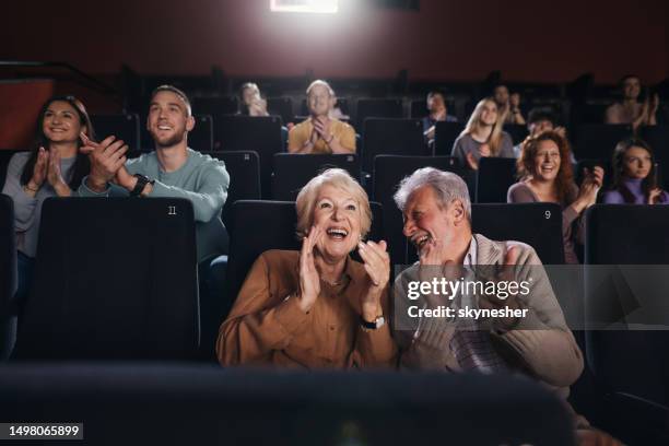 applauding after movie projection in theatre! - victor ovies stock pictures, royalty-free photos & images