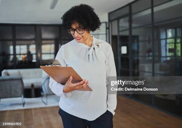 a mature businesswoman looks at and reads the documents in her office with copy space. stock photo - woman lipstick rearview stock pictures, royalty-free photos & images