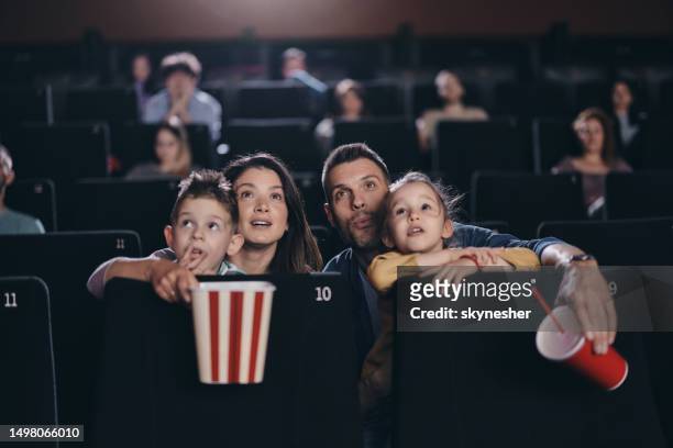 giovane famiglia che guarda una proiezione di film in teatro. - proiezione evento pubblicitario foto e immagini stock