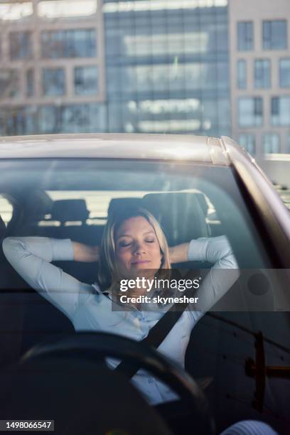 lächelnde geschäftsfrau, die sich in einem auto ausruht. - innere ruhe und blau stock-fotos und bilder