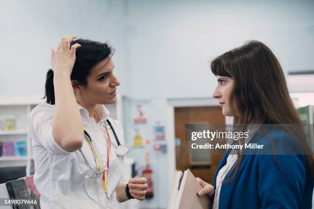 two work colleagues talking - zich op het hoofd krabben stockfoto's en -beelden