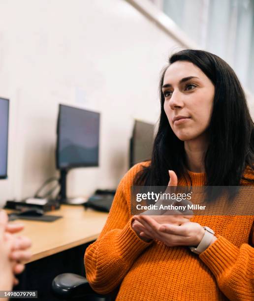 pregnant woman asking for help using sign language - sign language stock pictures, royalty-free photos & images