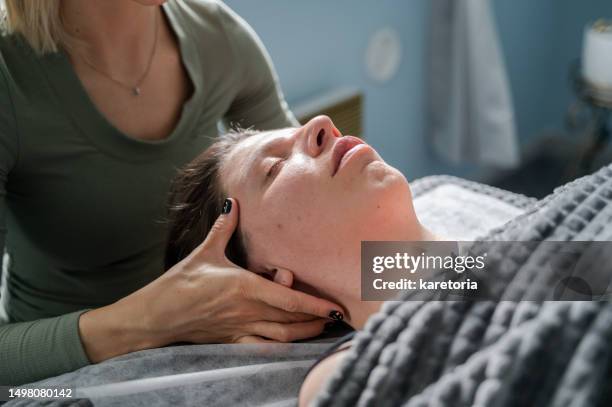 woman masseur doing face and head massage - facelift stock pictures, royalty-free photos & images