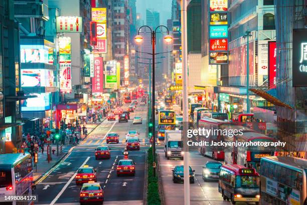 a vibrantly colored bustling cityscape with neon signs kowloon, hong kong china - hong kong taxi stock pictures, royalty-free photos & images