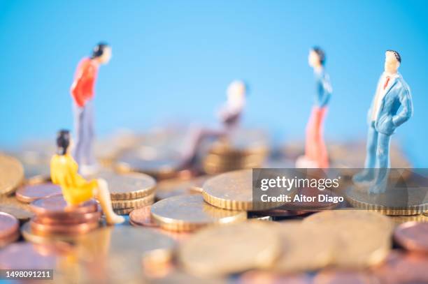 abundance of money.  symbolic image showing people (figurines) on mountains of money.. big bank concept. - erben stock-fotos und bilder