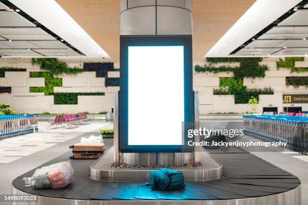 in the international airport, there is a blank advertising billboard with baggage and luggage. - baggage claim stock pictures, royalty-free photos & images