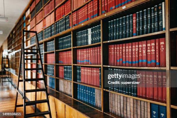 bookshelves with stacked hard cover books - public library stock pictures, royalty-free photos & images