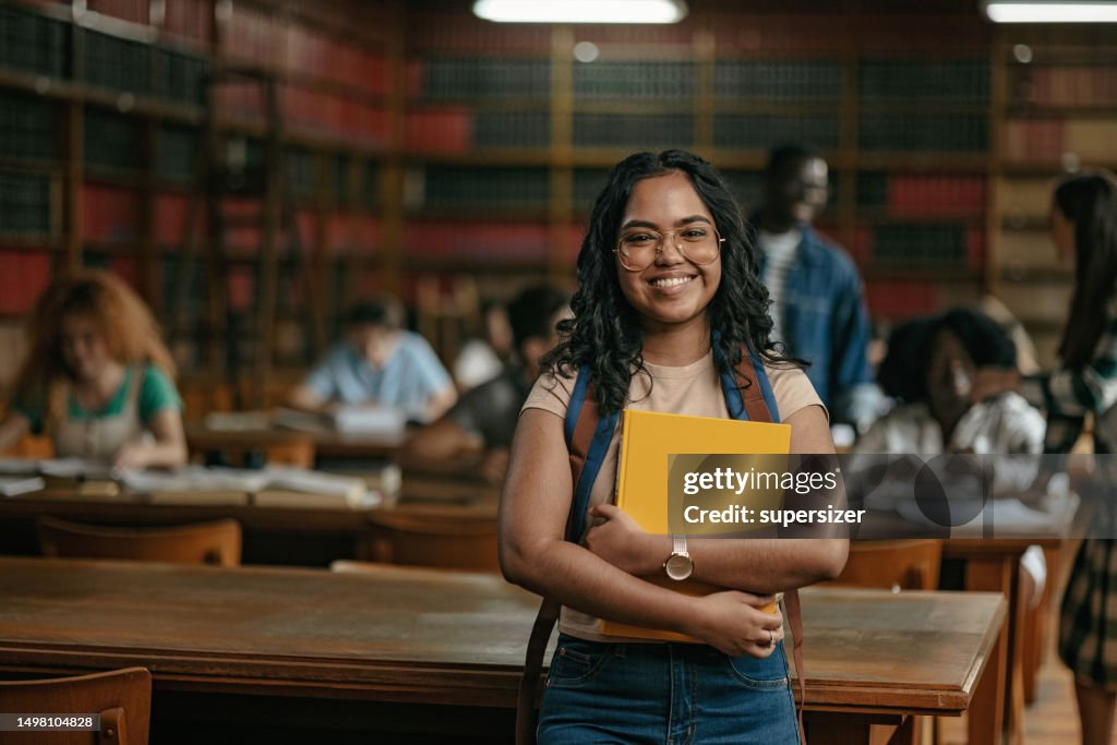 Hermoso retrato de estudiante india mientras mira a la cámara