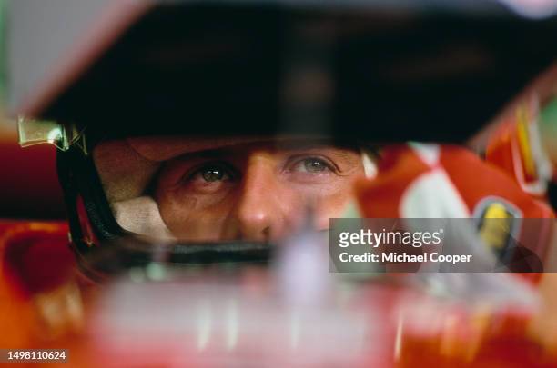 Michael Schumacher from Germany checks the lap times from the cockpit of the Scuderia Ferrari Marlboro Ferrari F310B Ferrari V10 during practice for...