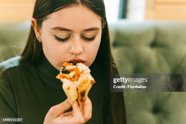 close-up portrait of a teenager girl eating pizza - burger portrait photos et images de collection