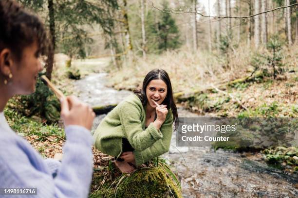 women brushing teeth by mountain stream - travel stock-fotos und bilder