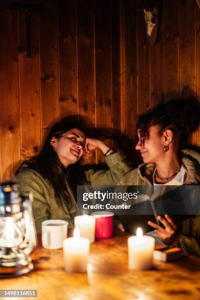friends reading book in evening - candlelight stock pictures, royalty-free photos & images