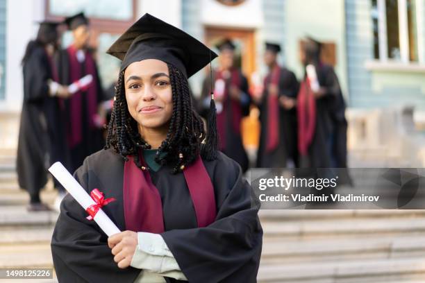 a smiling student is happy to receive her diploma - alumni bildbanksfoton och bilder