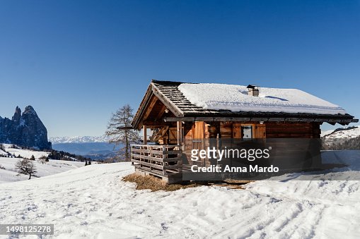 A wooden mountain hut in the snowy landscape of seiser alm