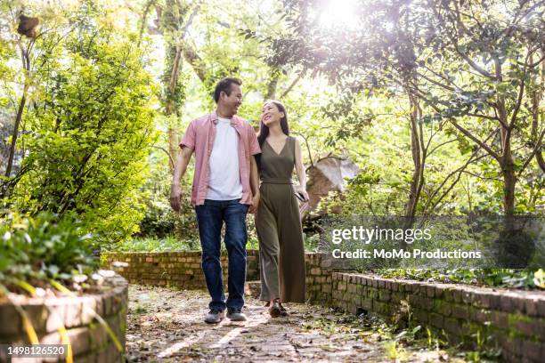 middle-aged couple walking through beautiful botanical garden - us botanic garden stock pictures, royalty-free photos & images